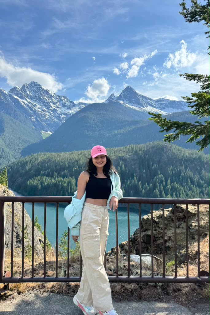 Khushboo standing before a mountain lake