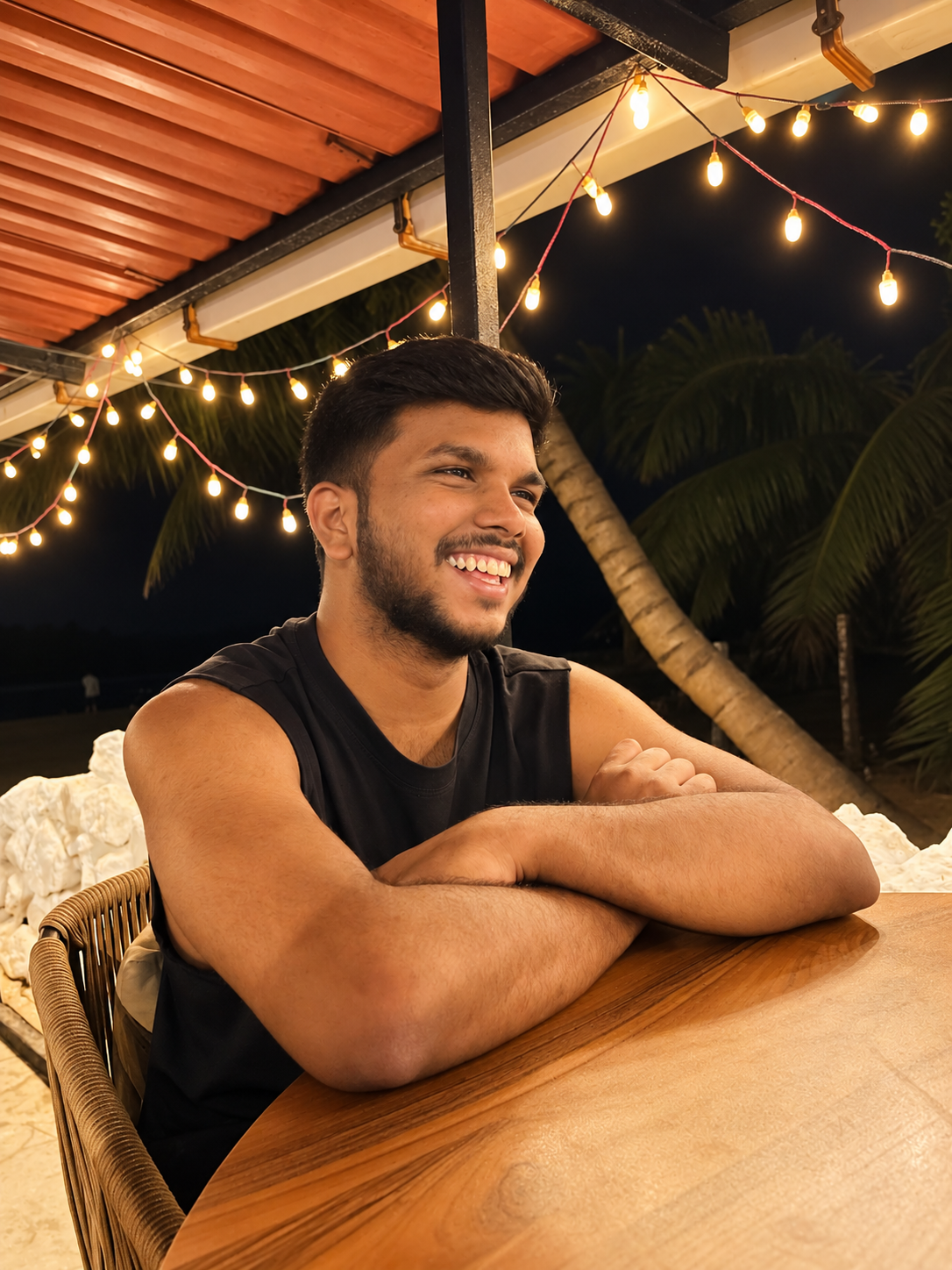 Parag smiling beneath string lights